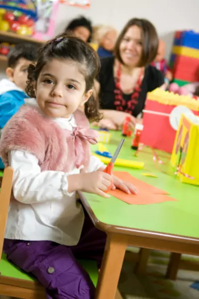 preschool-enroll Happy black teenager in headphones greeting his friend or teacher online, waving at camera from home