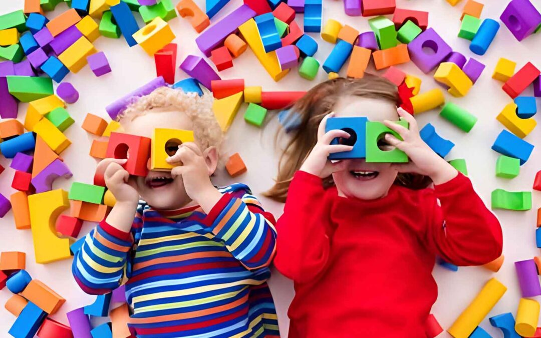 Two children joyfully playing with colorful blocks in a vibrant setting at Infant Care Centers near McKinney.