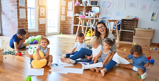 A woman and children are gathered on the floor of a classroom, enjoying a learning experience at the Pre K schools Frisco.