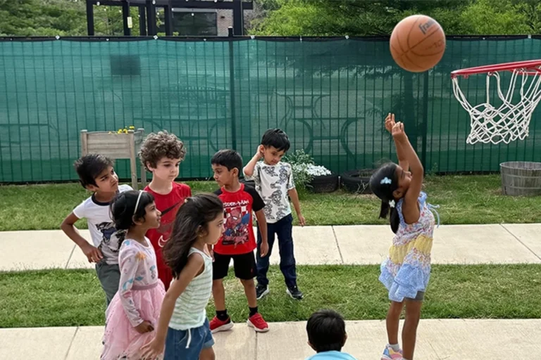 Children playing basketball on the outdoor court