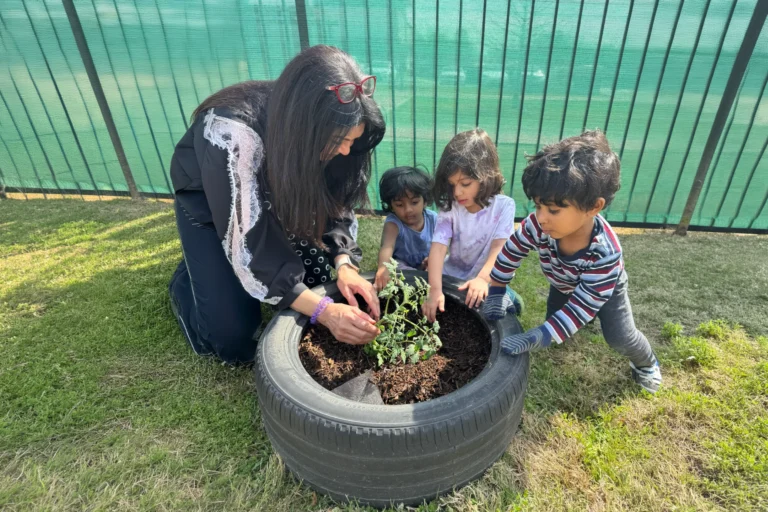 Teacher and children gardening in a repurposed tire planter