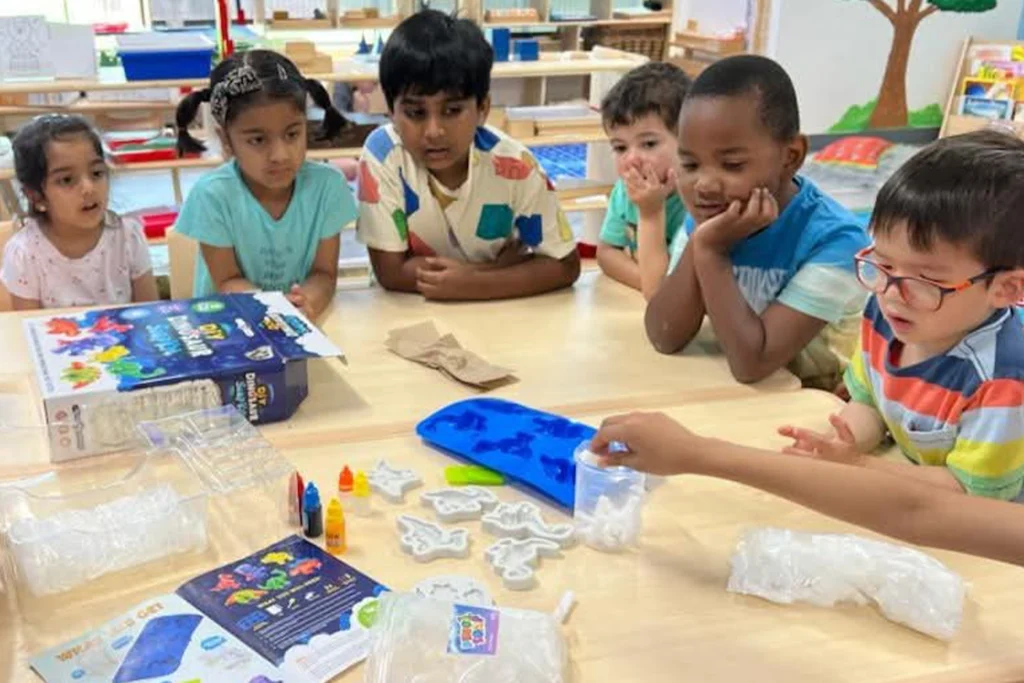 Pre-K students exploring a hands-on dinosaur STEM kit